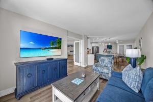 a living room with a blue couch and a tv at Hip Oceanfront Resort Vistas in Kihei