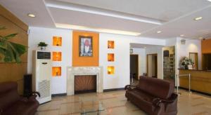 a living room with two chairs and a fireplace at Jinjiang Inn Select Shanghai Pudong Airport in Shanghai