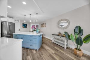 a kitchen with blue cabinets and a white counter top at Hip Oceanfront Resort Vistas in Kihei