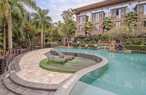 a swimming pool with a bench next to a building at The Mulian Urban Resort Hotels Huadu in Zhongluotan