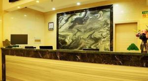 GreenTree Inn Jiangsu Changzhou Henglin Town Shuntong Road Express Hotel في تشانغتشو: لوبي به لوحة كبيرة على الحائط