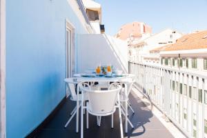 a balcony with a table and chairs on a building at ALTIDO Joyful 2BR Apt with terrace nearby São Bento Palace in Lisbon