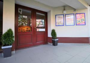 a red door of a building with two potted plants at Target Hostel in Zakopane