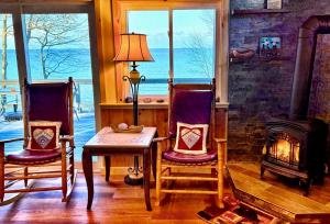 a living room with two chairs and a fireplace at Lakefront Oak Cottage Hot Tub & Fire Pit in Sodus