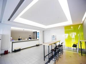 a lobby with two people sitting at a reception desk at Jinjiang Inn Dalian Jiefang Road in Dalian