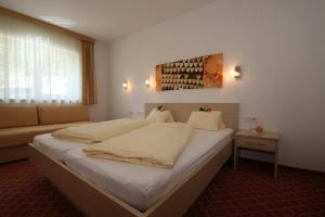 a bedroom with a large bed and a couch at Karlspitze -Natur Pur Appartementhaus in Kaunertal