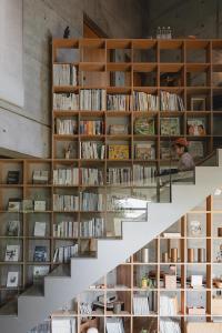 una escalera en una habitación llena de libros en Mao House, en Tainan