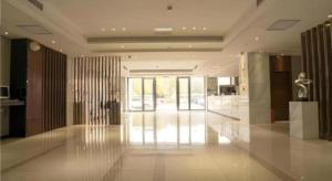 City Comfort Inn Wuhan High Speed Railway Station في ووهان: غرفة كبيرة مع ردهة ذات جدران زجاجية