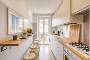 a kitchen with white cabinets and a counter with stools at Cinque Terre Stairway in La Spezia