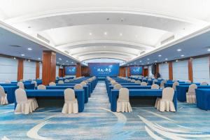 a large room with blue tables and white chairs at Huizhou Wanyun Holiday Hotel in Huangshan