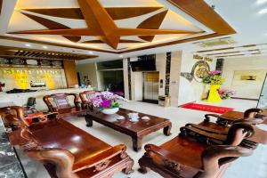 Binh Hung Hotel في مدينة هوشي منه: غرفة معيشة مع أثاث خشبي وسقف على شكل نجمة