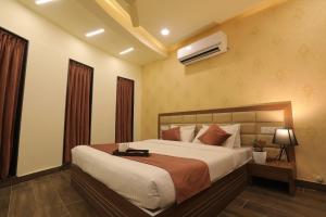 una camera da letto con un letto grande in una stanza di Hotel Shiv Shakti a Rajkot