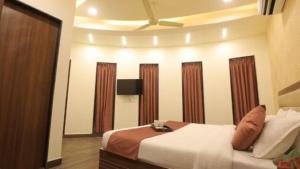 una stanza d'albergo con un letto e uno specchio di Hotel Shiv Shakti a Rajkot