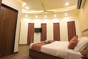 una camera con letto e ventilatore a soffitto di Hotel Shiv Shakti a Rajkot