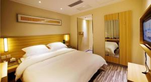 a bedroom with a large white bed and a television at City Comfort Inn Hengyang Dayang Department Lianhu Plaza in Hengyang