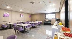 Lavande Hotel Wuhan Hanjiang Road Liuduqiao Metro Station في ووهان: مطعم به طاولات وكراسي أرجوانية في الغرفة
