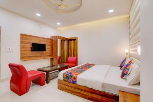 a bedroom with a bed and a desk and a tv at FabHotel The Elegant - 150 Meters From Delhi Public School Meerut in Anūpnagar