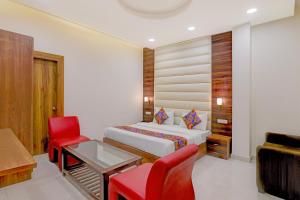 a bedroom with a bed and a desk and a chair at FabHotel The Elegant - 150 Meters From Delhi Public School Meerut in Anūpnagar +16 photos