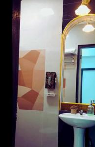 une salle de bains avec un lavabo et un miroir dans l'établissement Del Mar Residence, à Suizo 9 autres photos