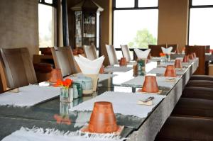 a long table with white plates and orange cones on it at Hananoie - A Permaculture Resort in Astam