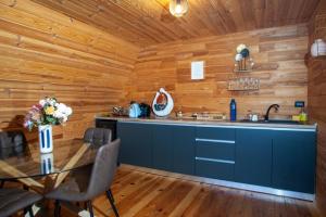 eine Küche mit Holzwänden, einem Tisch und einer Theke in der Unterkunft MGM BellaVista in Jieţ