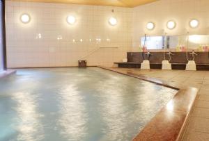 an empty swimming pool in a room with tiles at Miyajima Morinoyado in Miyajima