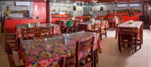 a dining room with tables and chairs and red walls at JR Hotel in João Pessoa