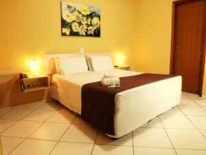 a bedroom with a large bed with two lamps at Londres Royal Hotel in Londrina