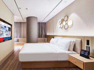 南京桔子酒店（南京江宁东南大学诚信大道店）的一间配有大床和平板电视的卧室