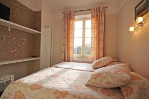 ein kleines Schlafzimmer mit einem Bett und einem Fenster in der Unterkunft Gite Le Relais Saint Michel in Domfront