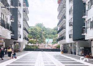 a woman and a child walking down a street between buildings at Jarrdin Apartment by CozyNest Syariah in Bandung +8 photos