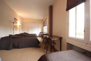 a bedroom with two beds and a table and a window at Gite Le Relais Saint Michel in Domfront