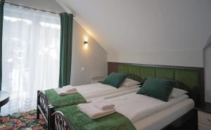 Villa Hasaba في كروتشيينكو: غرفة نوم بسرير كبير ومخدات خضراء وبيضاء