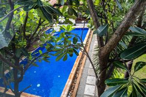 a blue swimming pool with trees around it at Angkor Serenity Hotel Siem Reap in Siem Reap