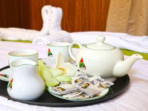 a tray with a tea pot and cups on a bed at Bestlife Eco Resort Mattala Airport in Maththala