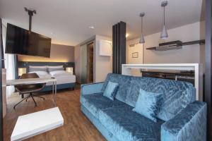 ein Wohnzimmer mit einem Sofa und einem Bett in der Unterkunft Design & Lifestyle Hotel Estilo in Aalen
