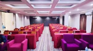 a large room with pink tables and purple chairs at Hotel 95 in Siantan