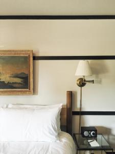 a bedroom with a bed with a painting and a lamp at Brentwood Hotel in Saratoga Springs