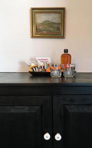 a black cabinet with bowls and a bottle on top at Brentwood Hotel in Saratoga Springs
