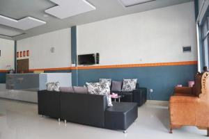 a living room with couches and a couch and a tv at Penginapan Arsyana in Tamperan