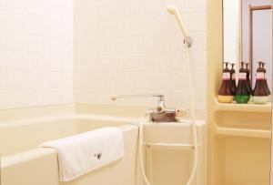 a bathroom with a bath tub with a towel at Miyajima Morinoyado in Miyajima +32 photos