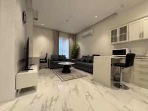 a living room with a couch and a table at Najd Cozy Apartments in Dammam