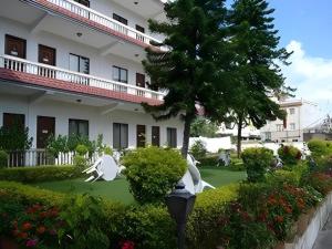Una estatua de dos pájaros en un jardín frente a un edificio. en Hotel Norbu Sangpo, en Katmandú
