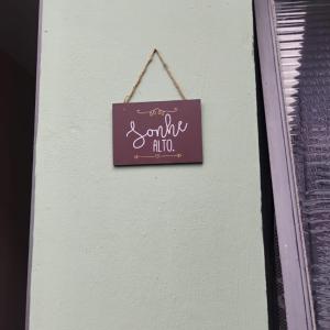 a sign hanging on the side of a wall at Hostel São Francisco 3 in Votorantim