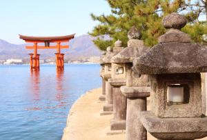 a row of stone buildings next to the water at Miyajima Morinoyado in Miyajima +25 photos