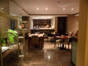 a dining room with tables and chairs in a restaurant at Amorsolo Mansion Hotel in Manila