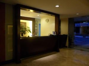an office lobby with a reception desk and a mirror at Amorsolo Mansion Hotel in Manila