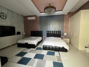 a bedroom with two beds and a chandelier at Highland Villas Royale Corp in Alfonso