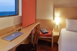 a room with a desk with a laptop and a bed at Ibis Cancun Centro in Cancún