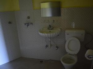 a bathroom with a toilet and a sink at Mystique Highland Resort in Astam +90 photos